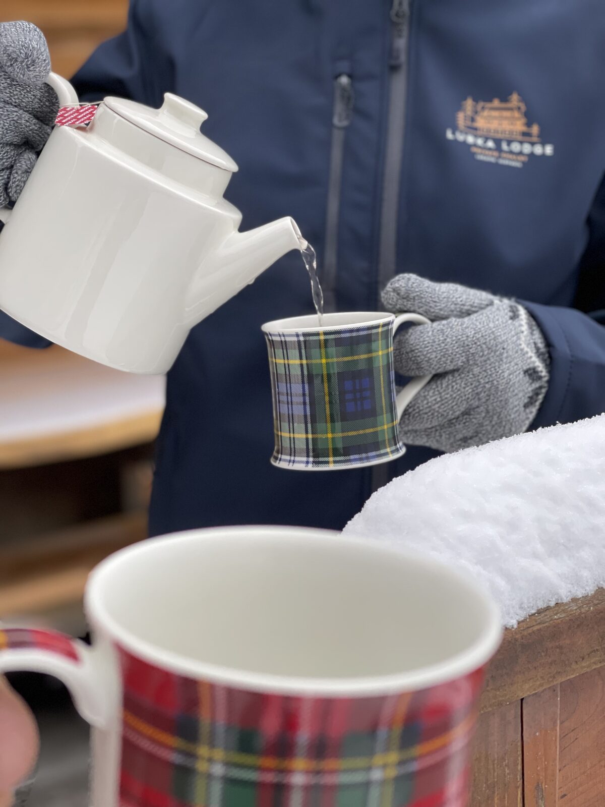 Pouring tea on the snowy terrace of Lubka Lodge